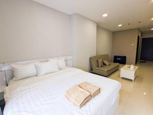 sypialnia z dużym białym łóżkiem i krzesłem w obiekcie Lovina 20-12B Formosa Residence w mieście Nagoja