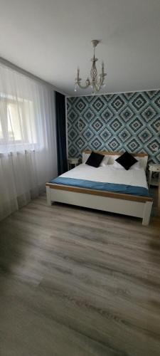 a bedroom with a bed and a chandelier at Casa Domnească in Giurgiu