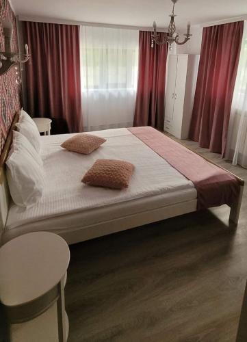a bedroom with a large bed with two pillows on it at Casa Domnească in Giurgiu