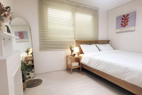 ein Schlafzimmer mit einem Bett und einem großen Fenster in der Unterkunft Hongdae Stn 2min 2R 1F #Core Stay 101 in Seoul