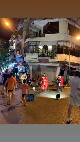 a group of people walking down a street at night at Old House Homestay in Hanoi