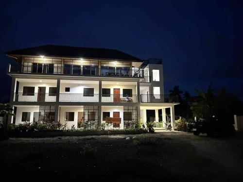 duży biały budynek z oświetleniem w nocy w obiekcie Sunset Ocean View @ Breeze Life. w Panglao City