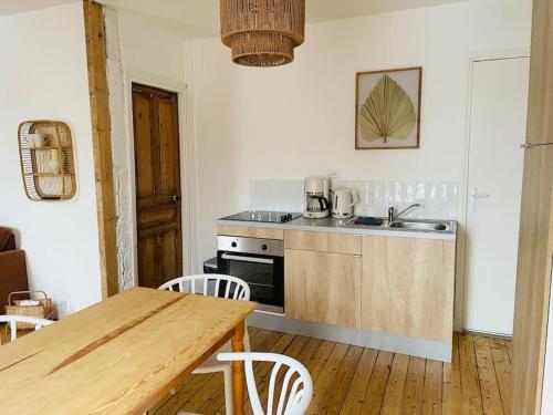 a kitchen with a wooden table and a kitchen with a table and chairs at Confort et Nature à Berck-Plage - détente ou travail - wifi in Berck-sur-Mer