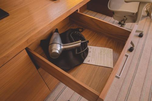 an open drawer with a hair dryer in it at Hilton Garden Inn Krasnoyarsk in Krasnoyarsk