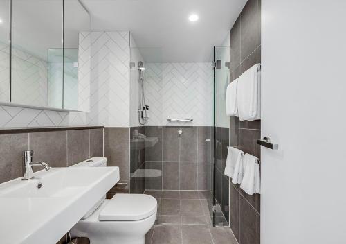 uma casa de banho com um WC, um lavatório e um chuveiro em Rambla at South City SQ em Brisbane
