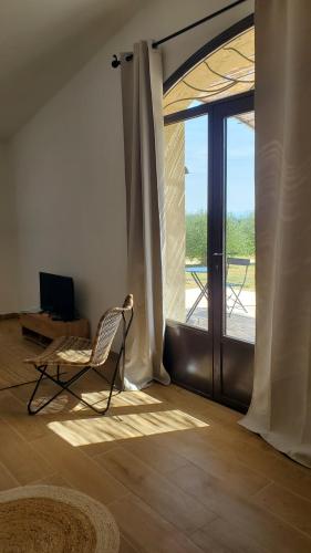 um quarto com uma cadeira e uma porta de vidro deslizante em Rêve en Lubéron em Lauris
