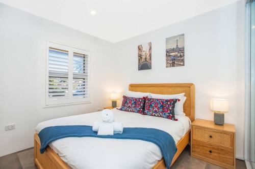 a bedroom with a bed with a teddy bear on it at Walk to Beach Escape @ Cronulla - 2Bdrm- Parking in Cronulla
