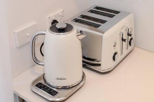 a white blender sitting on a counter next to a toaster at Walk to Beach Escape @ Cronulla - 2Bdrm- Parking in Cronulla