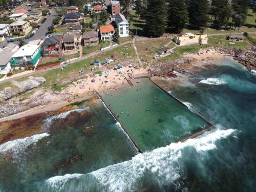 an aerial view of a beach with people in the water at Walk to Beach Escape @ Cronulla - 2Bdrm- Parking in Cronulla