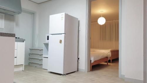 um frigorífico branco num quarto com uma cama em Seoul Vibes em Seul