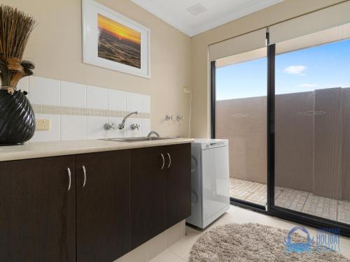 a kitchen with a sink and a sliding glass door at Canal Escape in Wannanup in Wannanup