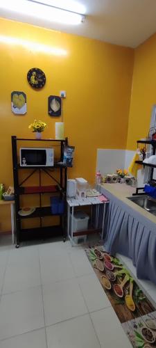 a kitchen with a counter and a yellow wall at lumut manjung homestay john faten in Lumut