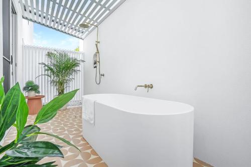 棕榈湾The Santana Collection TWO - Luxury Accomodation in the heart of Palm Cove的浴室配有白色浴缸和植物