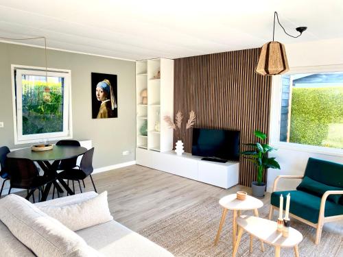 a living room with a couch and a table at Ruimte, privacy en comfort op de Veluwe, inclusief 2 fietsen & linnengoed in Nunspeet