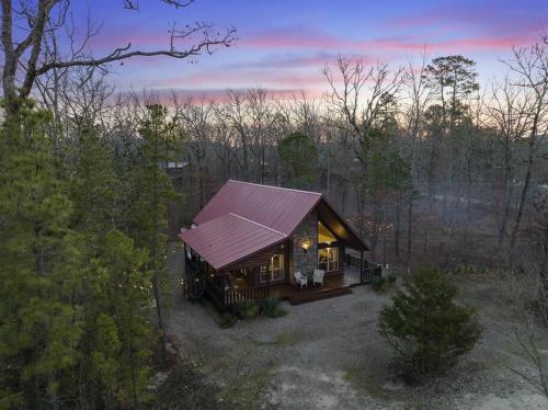 una pequeña cabaña en el bosque con techo púrpura en Waffle Ridge en Broken Bow