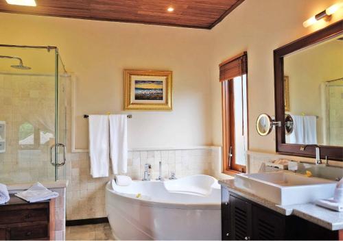 a bathroom with a large tub and a sink at Bagus Jati Health & Wellbeing Retreat in Tegalalang