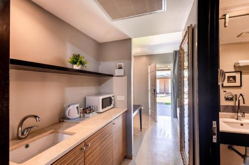 a kitchen with a sink and a microwave at Daria- Authentic Israeli Experience in Samra