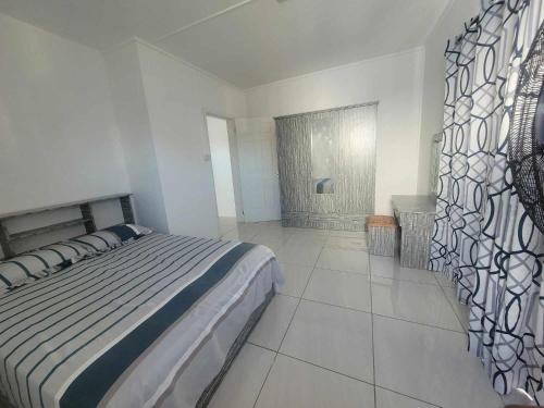 1 dormitorio con 1 cama grande en una habitación blanca en Duplex Melville, en Goodlands