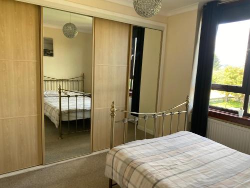 a bedroom with a bed and a large mirror at 2 Bed Apt - P&J Live, AWPR, Airport in Aberdeen