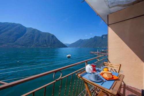 a table on a balcony with a view of the water at Colonno Fronte Lago in Colonno