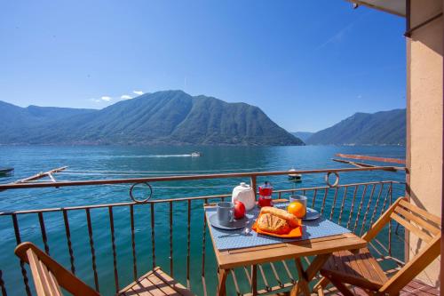 - une table sur un balcon avec vue sur l'eau dans l'établissement Colonno Fronte Lago, à Colonno