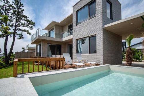 una casa con piscina delante en Ililsagye, en Seogwipo
