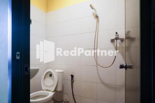 y baño con aseo blanco y ducha. en RedDoorz at Sparkling Hotel Surabaya, en Surabaya