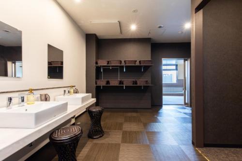 La salle de bains est pourvue de 2 lavabos et de 2 tabourets. dans l'établissement The Celecton Gotemba Interchange, à Gotemba