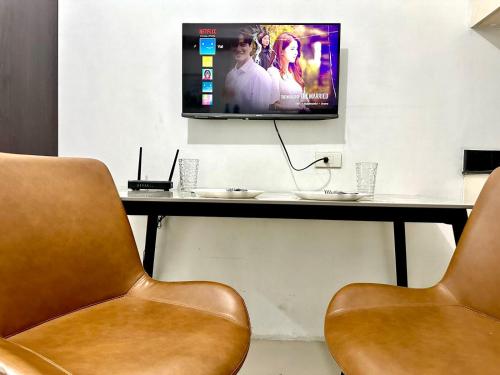 2 sillas en una habitación con TV en una mesa en Sea Residences Apartment by Kevin Alano, en Manila