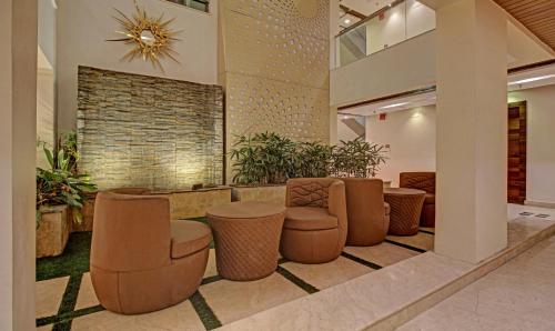 a lobby with brown stools and chairs in a building at Hotel Radiant in Kolkata