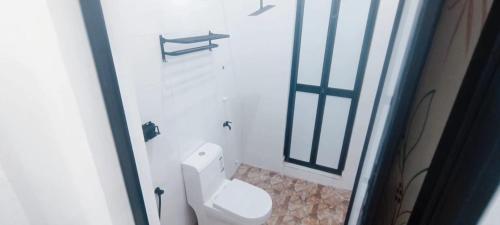 a white toilet in a bathroom with a window at Homestay Asam Pedas Parit Jawa Muar in Bakar Parit