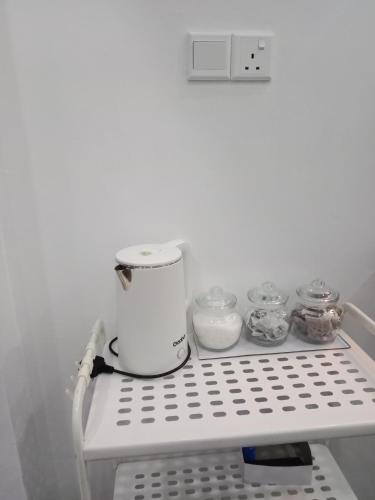 a white appliance sitting on a shelf in a refrigerator at Homestay Asam Pedas Parit Jawa Muar in Bakar Parit