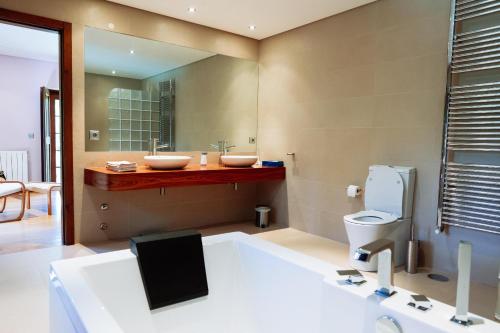 a bathroom with two sinks and a large mirror at Casa das Gandas in Celeiró do Monte