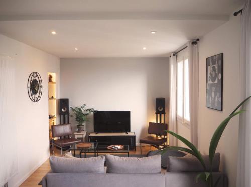 un salon avec un canapé et une télévision dans l'établissement T2 style industriel avec balcon, à Toulouse