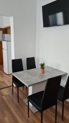 a dining room table with chairs and a table at HÉDER APARTMANOK in Balatonfenyves