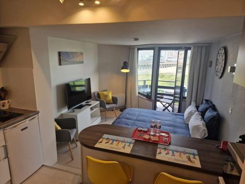 une chambre avec un lit et une cuisine avec une table dans l'établissement Le cocooning-studio Deauville Marina avec terrasse vue mer et plage, à Deauville
