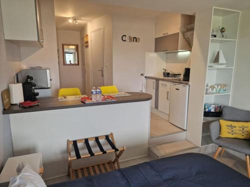 a living room with a kitchen and a counter in a room at Le cocooning-studio Deauville Marina avec terrasse vue mer et plage in Deauville