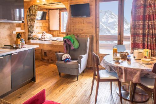 une cuisine et une salle à manger avec une table dans une cabine dans l'établissement Reine Blanche Appartements VTI, à Val Thorens