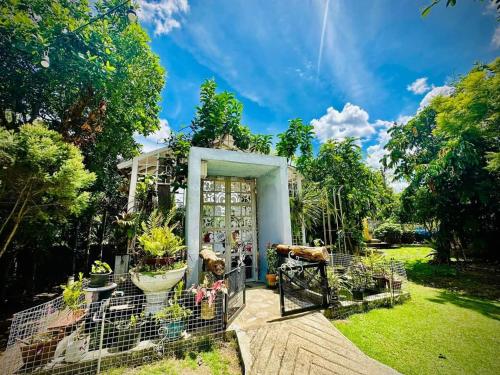 una entrada al jardín de una casa con plantas en Na Na Doo Homestay, en Chiang Rai