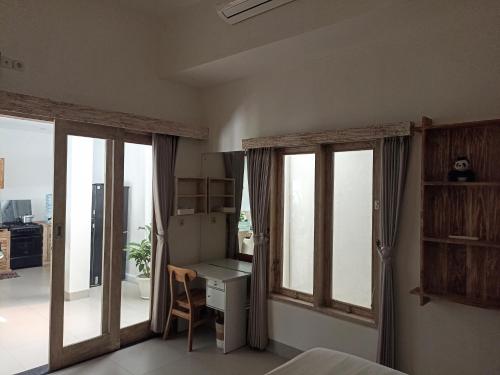 a bedroom with sliding doors and a desk and a table at Villa Of Course x Kerobokan x Canggu x Seminyak in Kerobokan