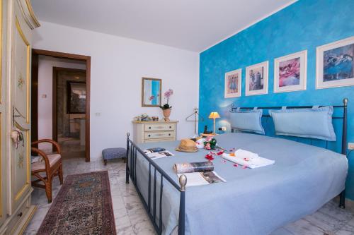 1 dormitorio con 1 cama grande y pared azul en Veranda di Menaggio, en Menaggio
