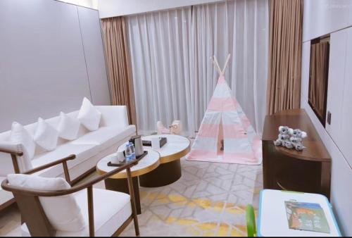 a living room with a white couch and a christmas tree at Qingyuan Argyle Hotel in Qingyuan