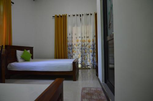 a small bedroom with a bed and a shower at Binara Home Stay in Polonnaruwa