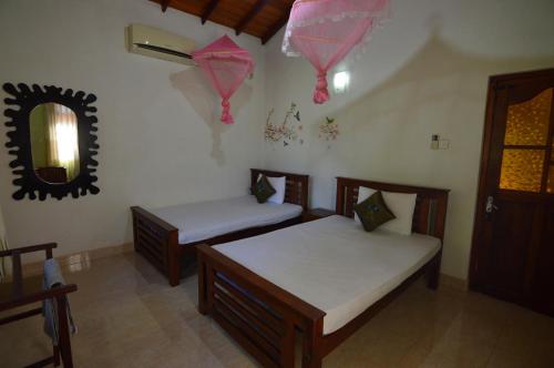 a room with two beds and kites hanging on the wall at Binara Home Stay in Polonnaruwa