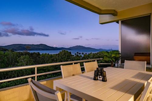 a dining table on a balcony with a view of the ocean at Poinciana Lodge - 2 bedroom - on Hamilton Island by HIHA in Hamilton Island