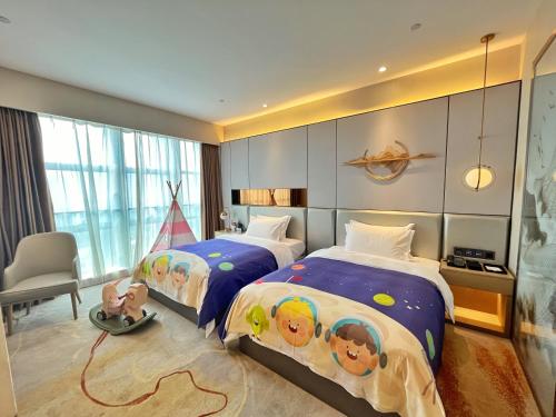 a bedroom with two beds with children on them at Qingyuan Argyle Hotel in Qingyuan