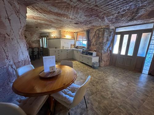 a kitchen and dining room with a wooden table and chairs at Comfort Inn Coober Pedy Experience in Coober Pedy