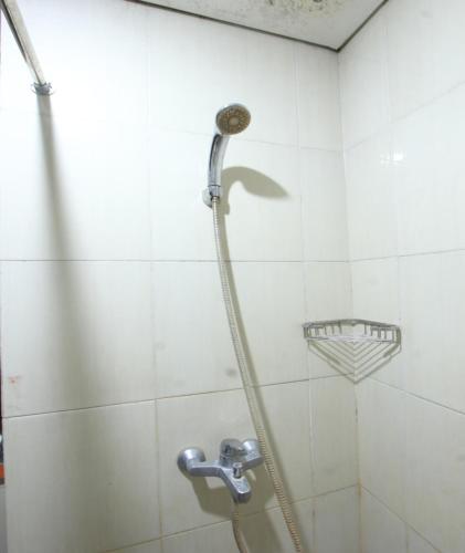 La salle de bains est pourvue d'une douche avec un tuyau. dans l'établissement OYO 93002 Kost Gayus, à Tjakranegara