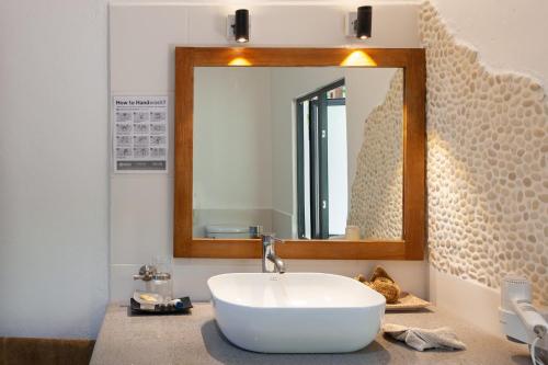 a bathroom with a white sink and a mirror at Cote Mer villa in Baie Sainte Anne