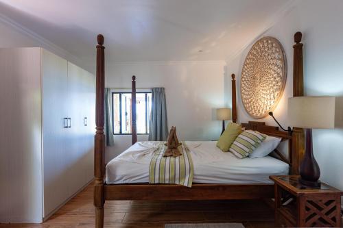 1 dormitorio con 1 cama con marco de madera en Cote Mer villa en Baie Sainte Anne